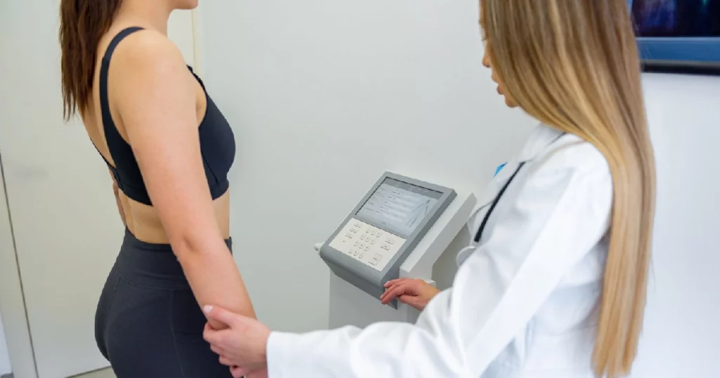 A woman undergoing a body composition analysis using the Styku 3D Body Scanner in Humble, TX, with a professional health expert.