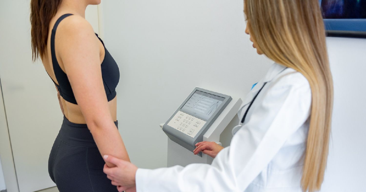 A woman undergoing a body composition analysis using the Styku 3D Body Scanner in Humble, TX, with a professional health expert.